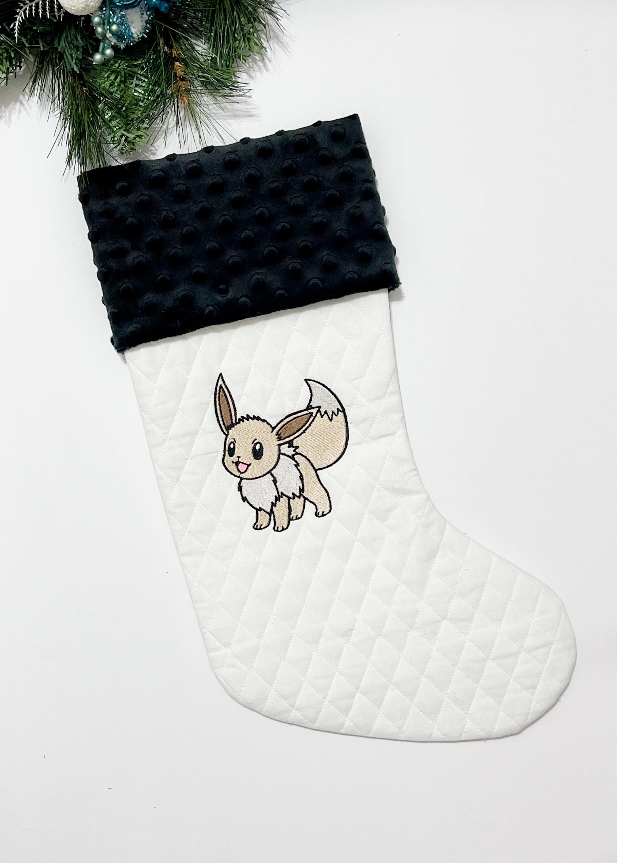 Personalized Christmas stocking made from white quilted fabric featuring embroidered Eevee evolution on front, fully lined, and minky cuff