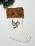Personalized Christmas stocking made from white quilted fabric featuring embroidered Eevee evolution on front, fully lined, and minky cuff