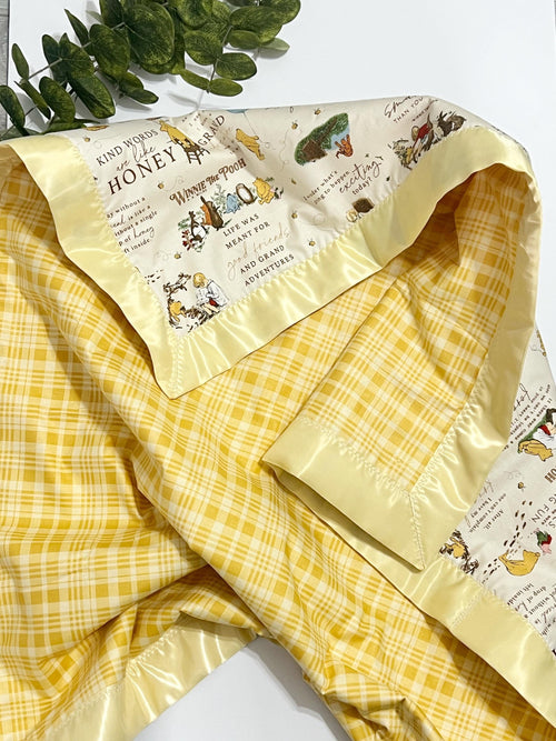 Baby crib blanket in classic Winnie the Pooh cotton with coordinating cotton on the back trimmed in satin binding, personalize option