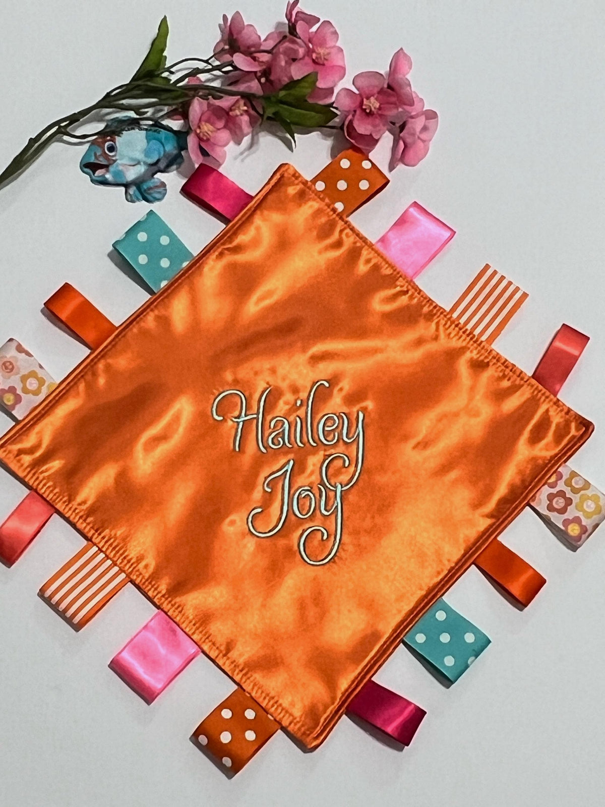 Double sided satin sensory lovey in ocean coral, hot pink, turquoise and orange with ribbon tags, and batting layer, comfort for baby, adult