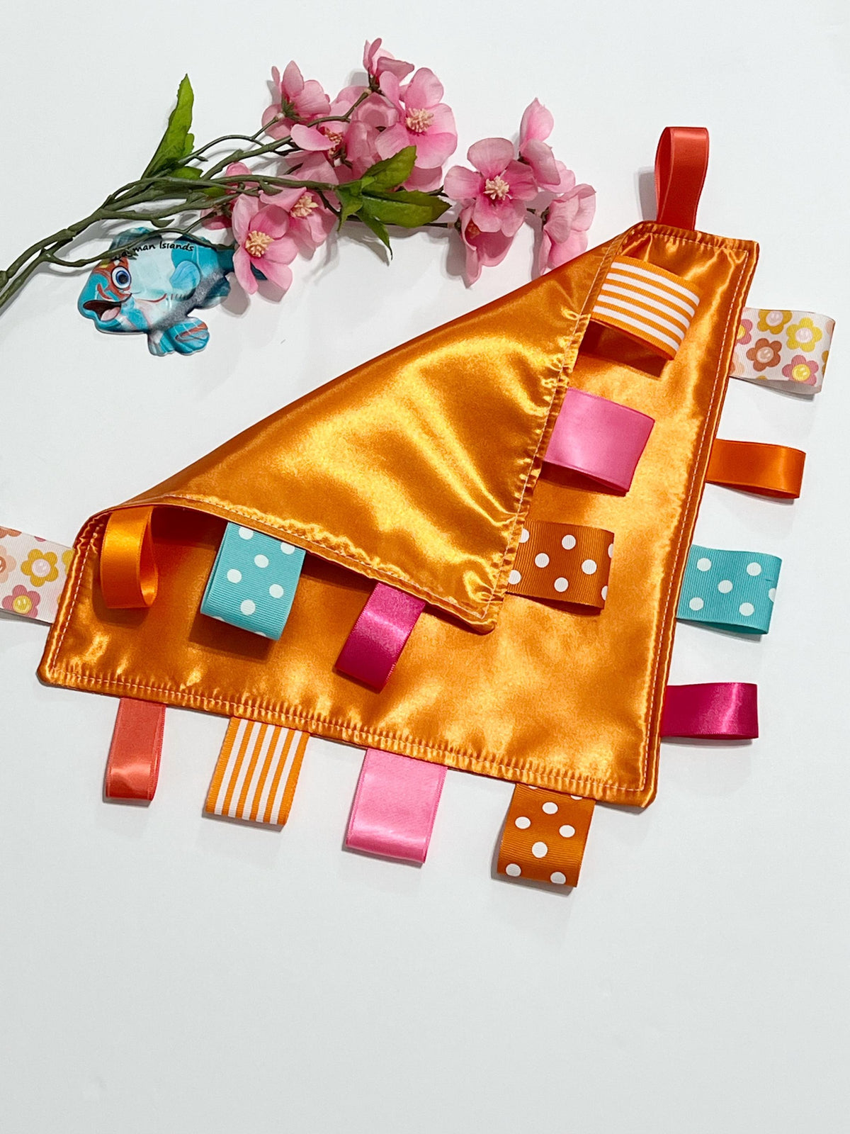 Double sided satin sensory lovey in ocean coral, hot pink, turquoise and orange with ribbon tags, and batting layer, comfort for baby, adult
