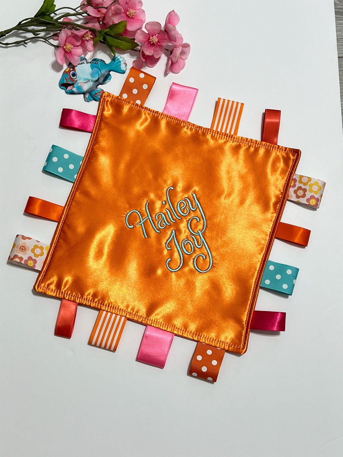 Double sided satin sensory lovey in ocean coral, hot pink, turquoise and orange with ribbon tags, and batting layer, comfort for baby, adult